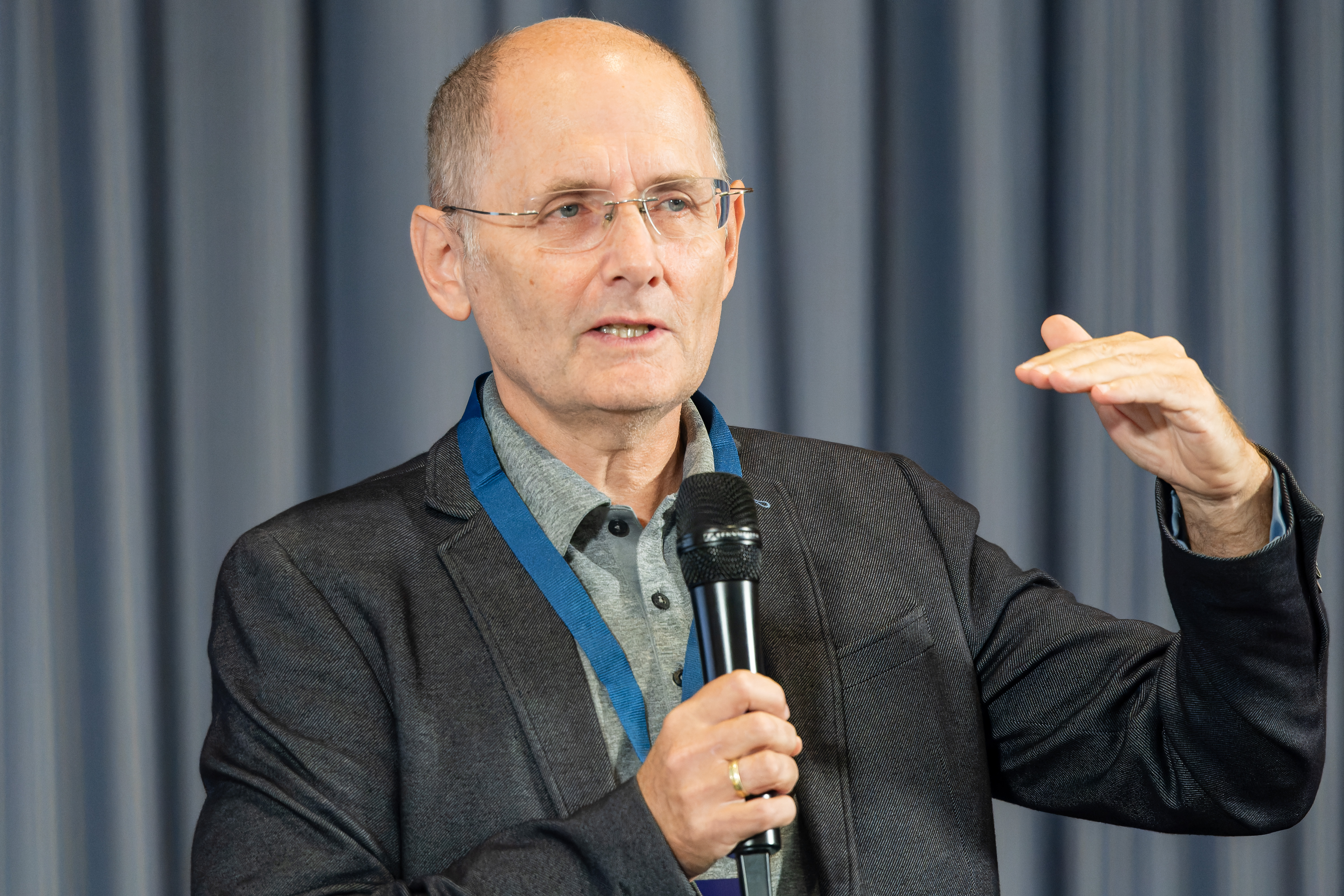 Foto von Klaus Miesenberger, der in ein Mikrofon spricht und gestikuliert