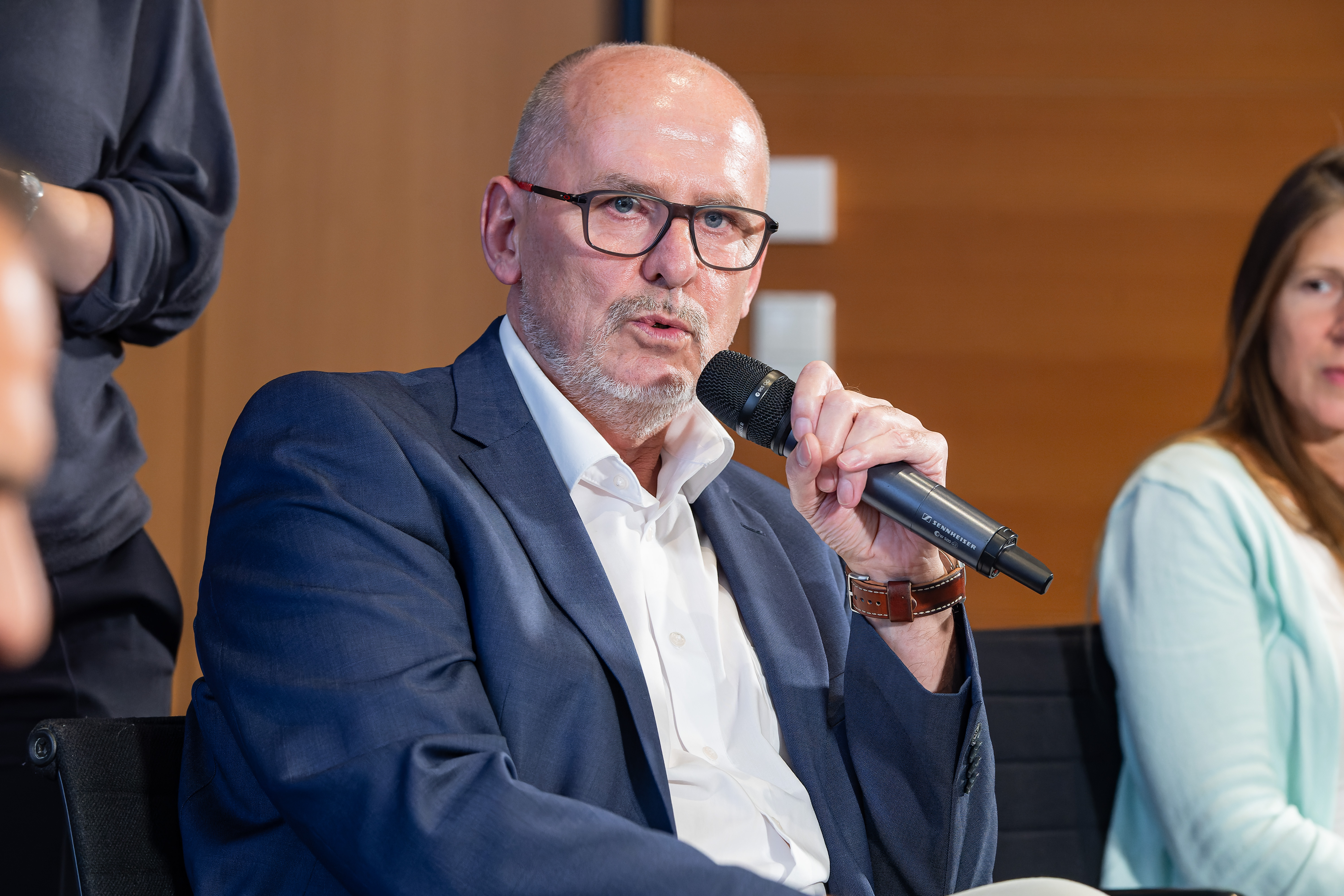 Foto von Frank Schrapper, der gerade in ein Mikrofon spricht.